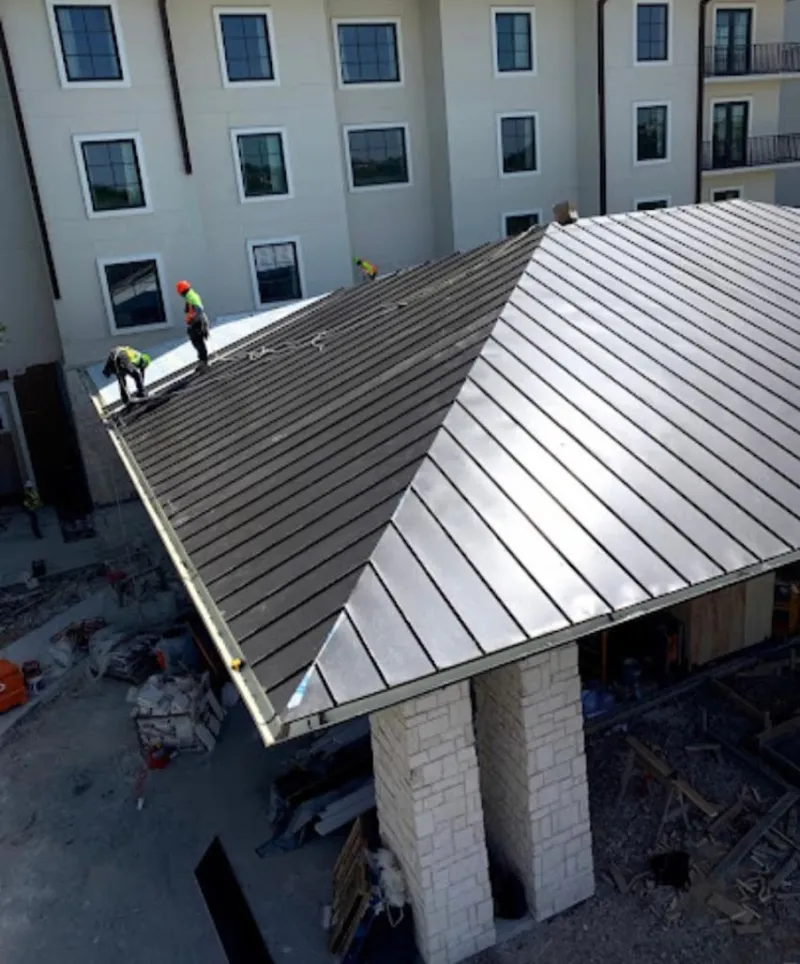 Crew installing standing seam metal roof panels on a commercial project in Nocatee